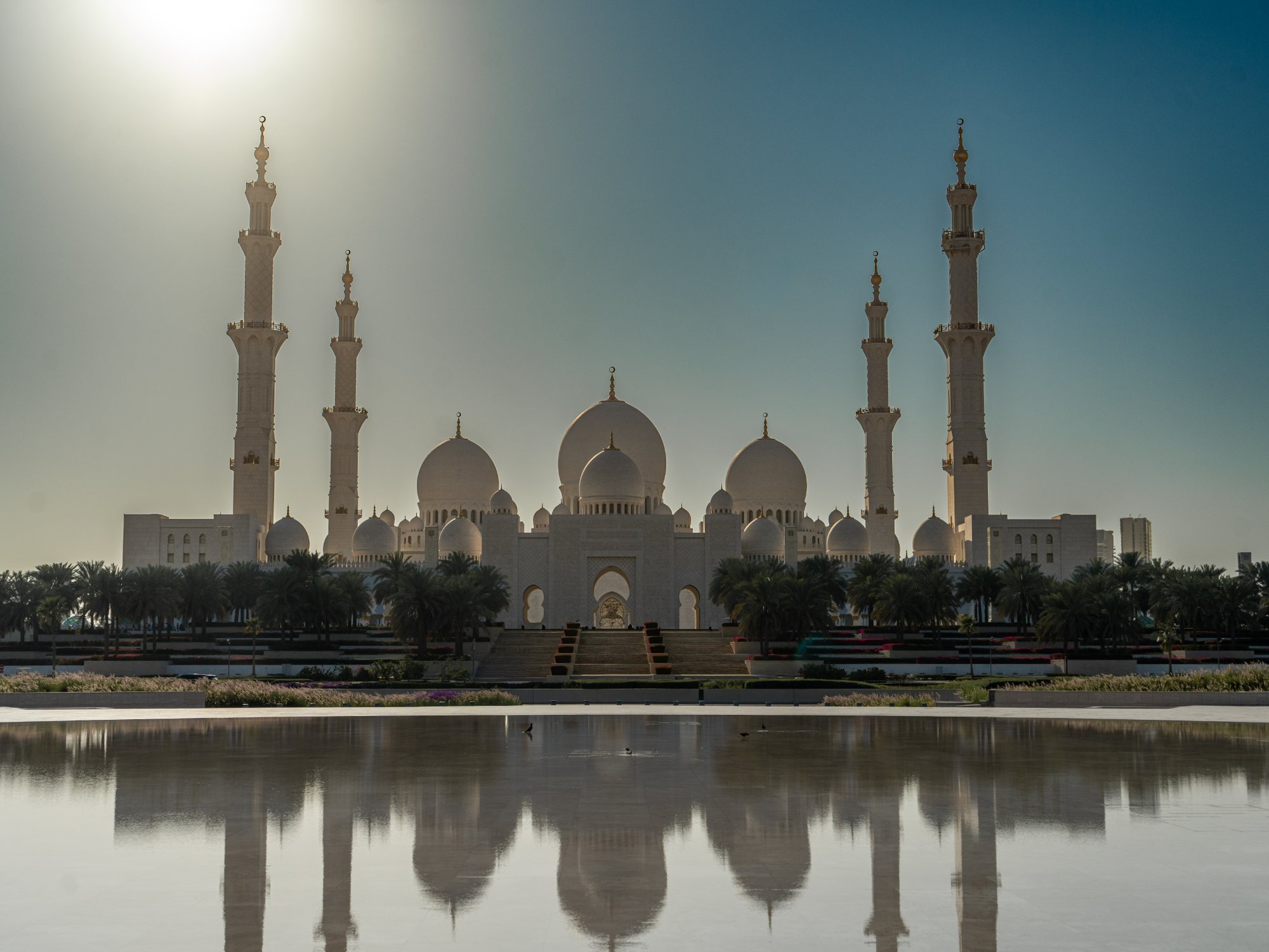 Sheikh Zayed Grand Mosque reflected in still water at golden hour, Abu Dhabi, UAE