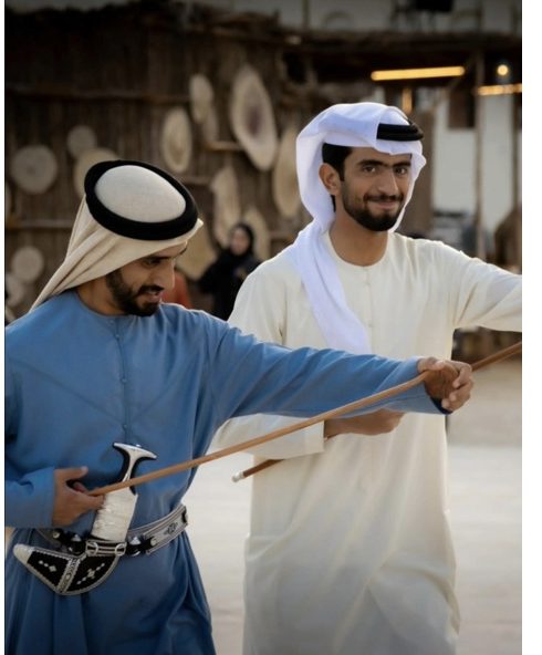 Two Emirati men in traditional dress at a cultural heritage site in the UAE